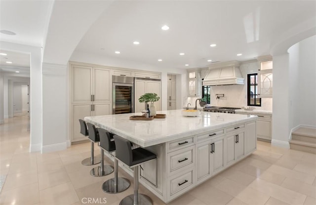 21 Observatory, Newport Coast, CA 92657 - kitchen with beverage cooler, custom exhaust hood, recessed lighting, decorative backsplash, and a large island