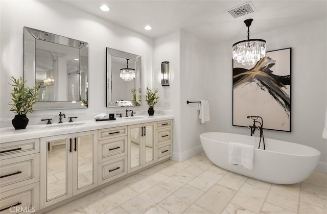 bathroom featuring a sink, marble finish floor, a notable chandelier, and a soaking tub