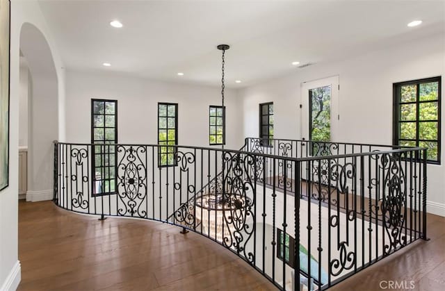 hallway featuring an upstairs landing, a wealth of natural light, recessed lighting, and wood-type flooring