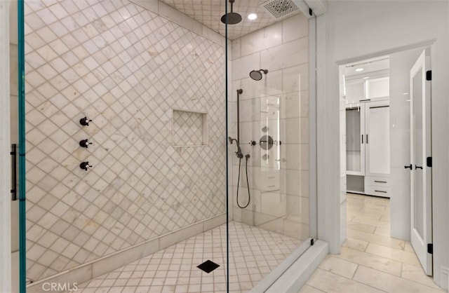bathroom featuring visible vents and a tile shower