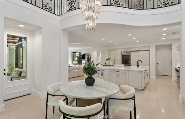 dining space with baseboards, an inviting chandelier, arched walkways, recessed lighting, and wine cooler