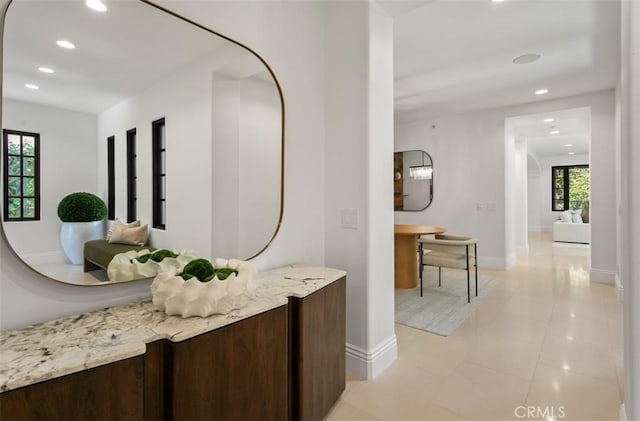 hall featuring light tile patterned floors, recessed lighting, and baseboards