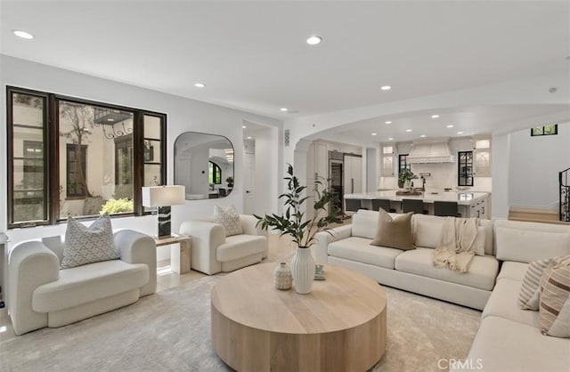 living area with recessed lighting and arched walkways