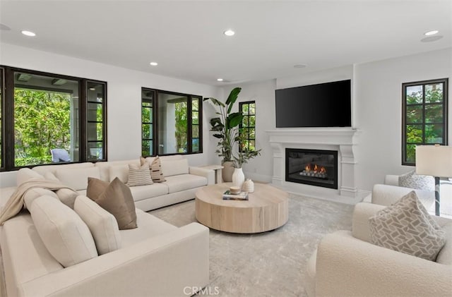 living area featuring recessed lighting and a glass covered fireplace
