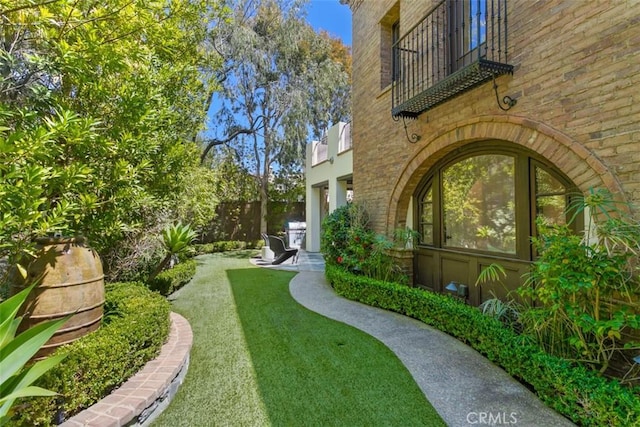 view of yard with fence and a balcony
