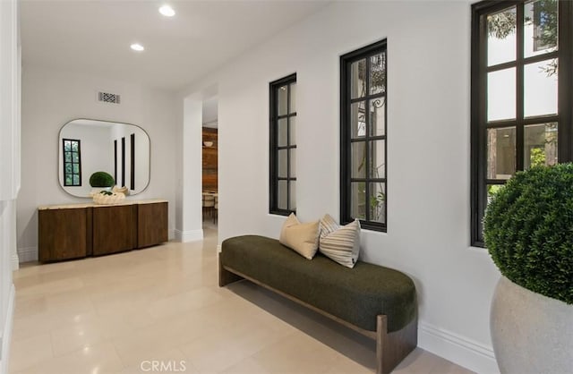 hallway with baseboards, visible vents, and recessed lighting