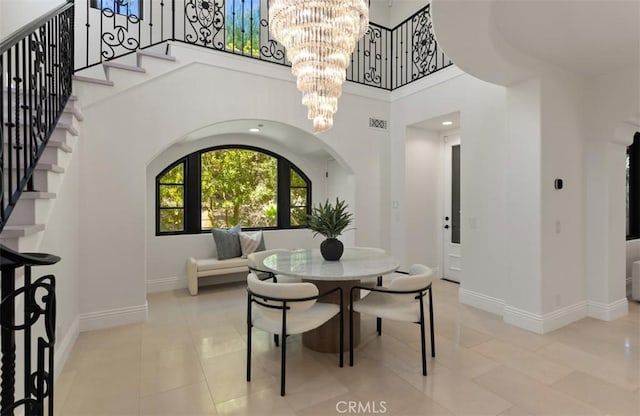 21 Observatory, Newport Coast, CA 92657 - tiled dining area with a chandelier, stairs, arched walkways, and a towering ceiling