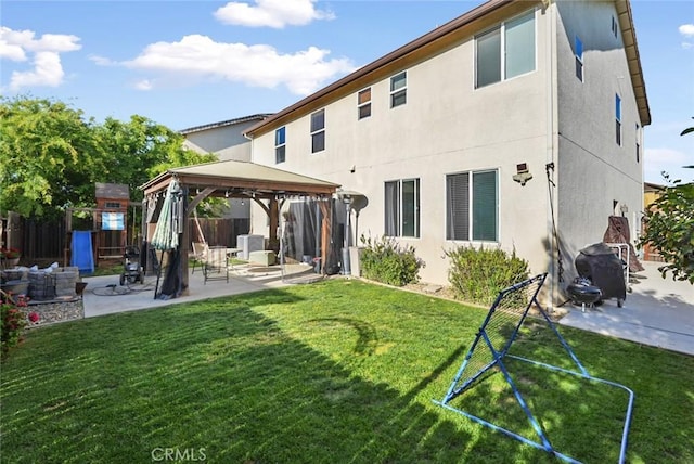 back of property with a gazebo, a patio area, fence, and stucco siding