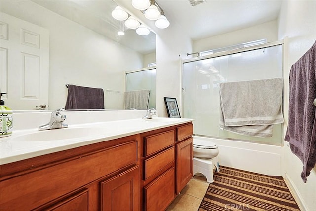bathroom featuring tile patterned floors, enclosed tub / shower combo, double vanity, and a sink