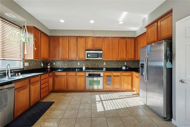 kitchen with a sink, brown cabinetry, and stainless steel appliances