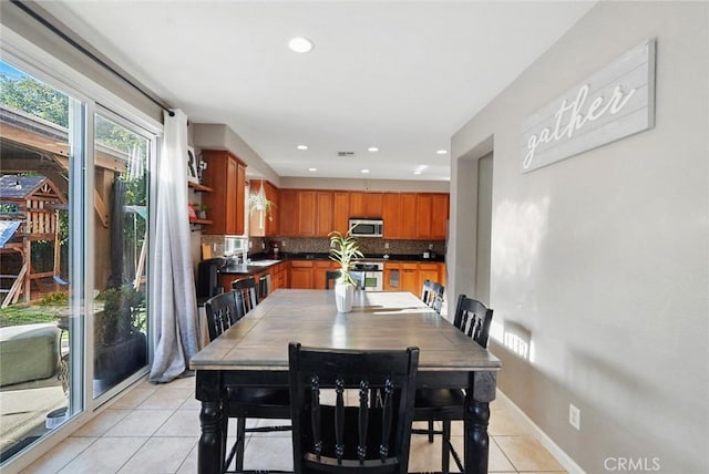 dining area with light tile patterned floors, baseboards, and recessed lighting