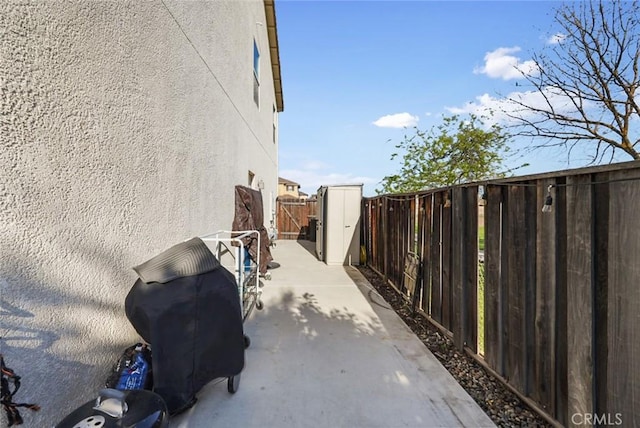 view of side of property featuring a patio, stucco siding, and fence