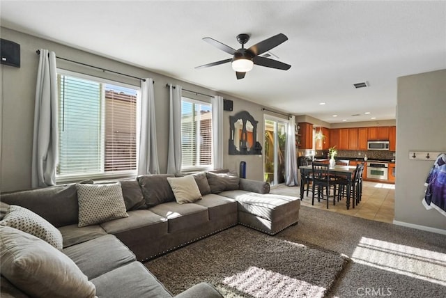 living area featuring light carpet, recessed lighting, light tile patterned floors, visible vents, and ceiling fan