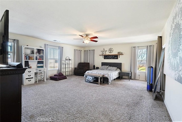 carpeted bedroom featuring visible vents and a ceiling fan