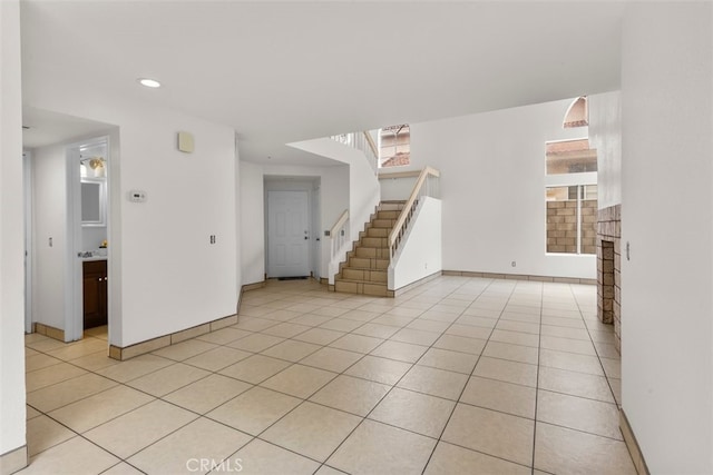 15767 San Roque Rd, Fontana, CA 92337 - unfurnished living room featuring stairway, light tile patterned flooring, baseboards, and recessed lighting