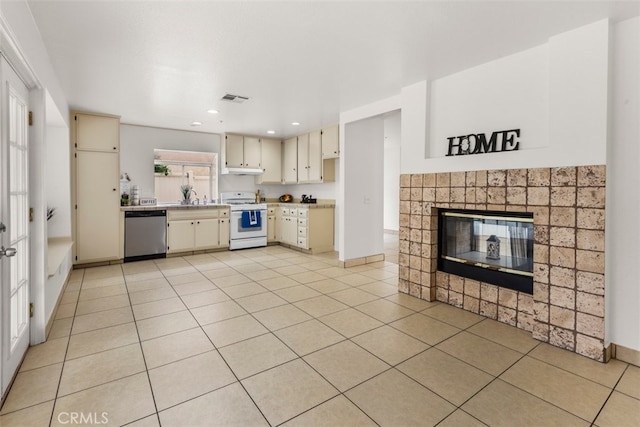 15767 San Roque Rd, Fontana, CA 92337 - kitchen with gas range gas stove, dishwasher, cream cabinetry, a tile fireplace, and light countertops