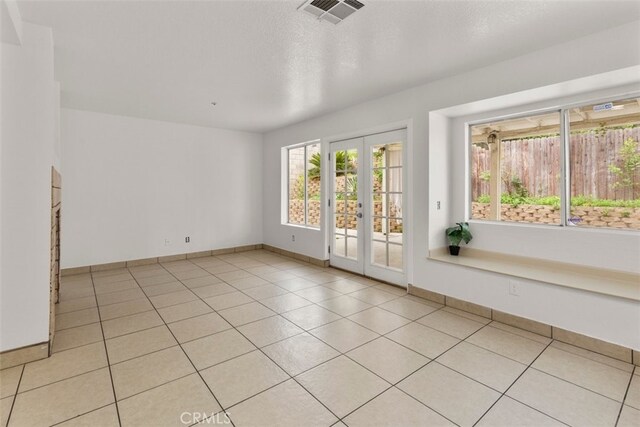 15767 San Roque Rd, Fontana, CA 92337 - spare room featuring french doors, baseboards, and light tile patterned floors