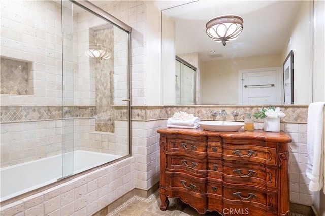 bathroom featuring vanity, tile patterned floors, visible vents, tiled shower / bath combo, and tile walls