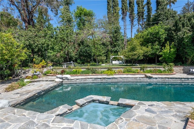 view of pool with a pool with connected hot tub