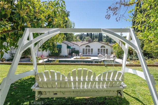 view of property's community featuring a swimming pool, a patio, and a lawn