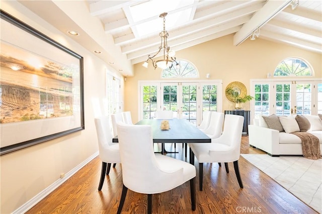 dining area with baseboards, lofted ceiling with beams, recessed lighting, wood finished floors, and french doors