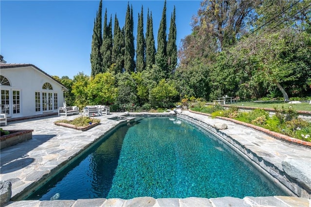 pool with a patio area and french doors