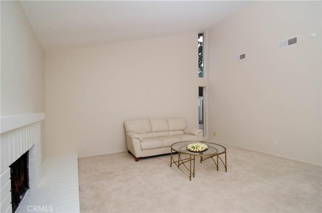 carpeted living area with visible vents and a brick fireplace
