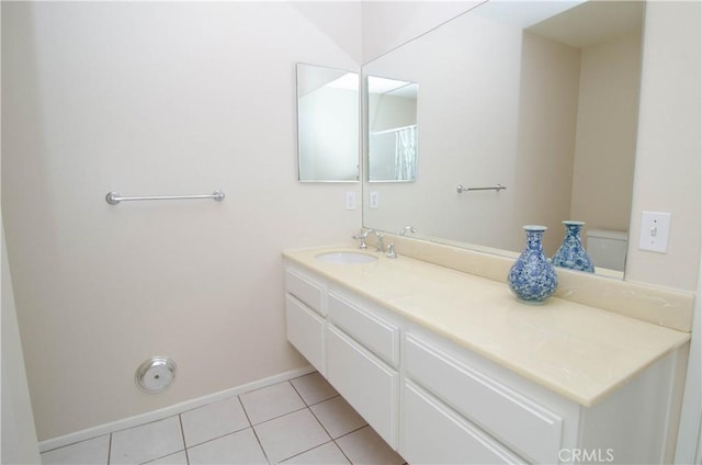 bathroom with tile patterned floors, baseboards, and vanity
