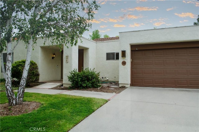 mediterranean / spanish-style home featuring stucco siding, driveway, and an attached garage
