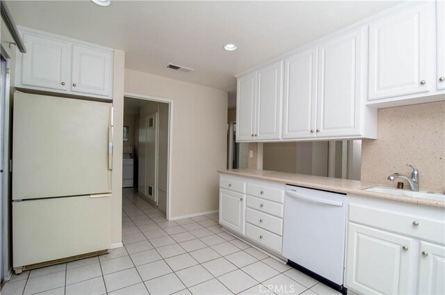 kitchen featuring a sink, visible vents, light countertops, light tile patterned flooring, and white appliances
