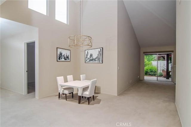 carpeted dining room with high vaulted ceiling and baseboards