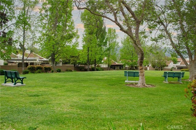 view of community featuring a lawn and fence