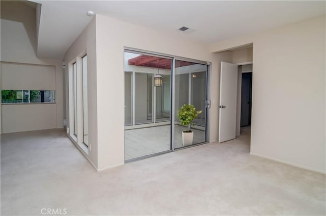 carpeted spare room featuring visible vents