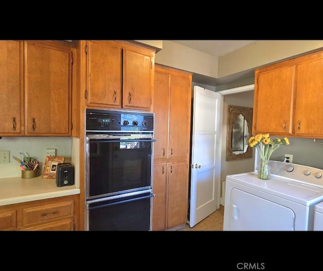 kitchen with washer and dryer, dobule oven black, light countertops, and brown cabinets