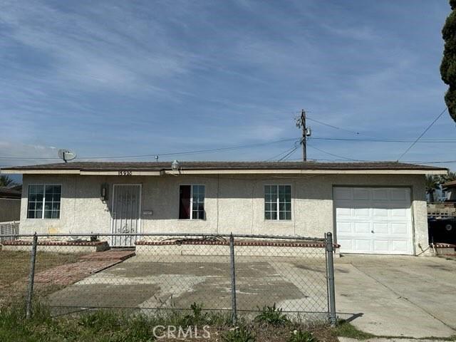 15920 Mission Ave, Fontana, CA 92335 - ranch-style house featuring an attached garage, driveway, stucco siding, and fence