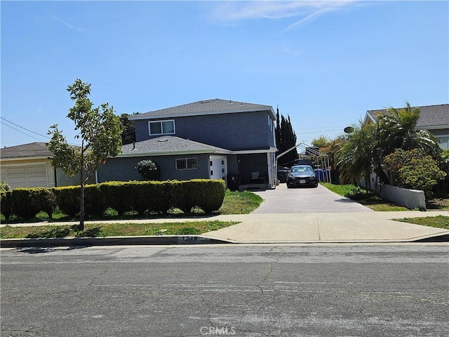 traditional-style house with concrete driveway and stucco siding