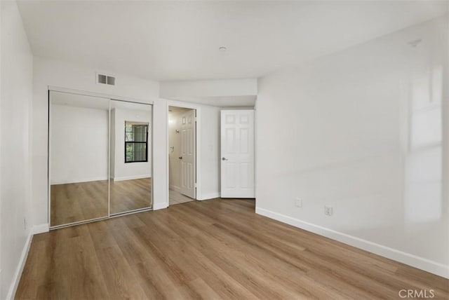 1044 Calle Del Cerro Unit 301, San Clemente, CA 92672 - unfurnished bedroom featuring a closet, baseboards, and wood finished floors