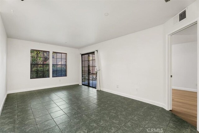 1044 Calle Del Cerro Unit 301, San Clemente, CA 92672 - empty room featuring visible vents, baseboards, and dark tile patterned flooring