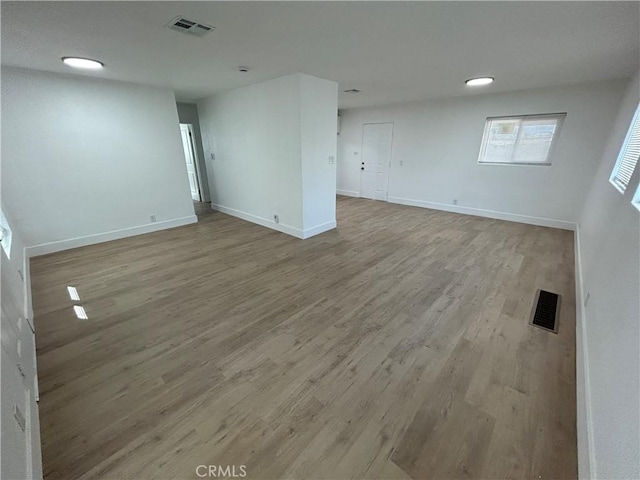 interior space with baseboards, wood finished floors, and visible vents