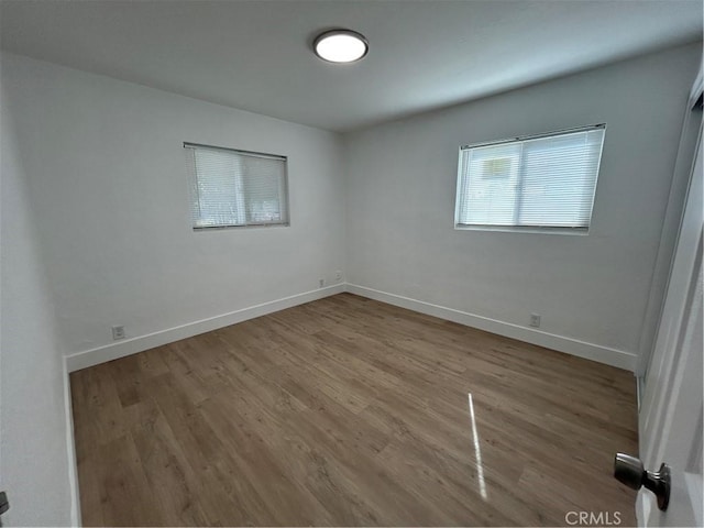 empty room with wood finished floors and baseboards