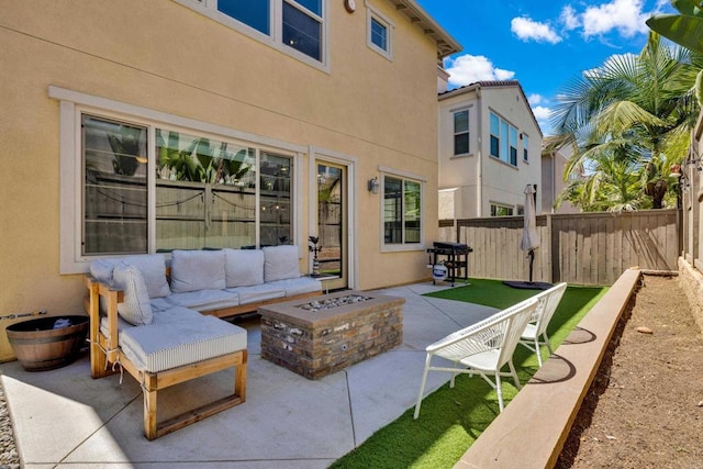 view of patio with fence and an outdoor living space with a fire pit