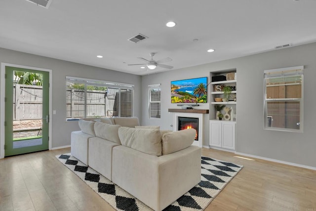 1132 Cherry Tree Ln, Vista, CA 92084 - living room with light wood finished floors, recessed lighting, a glass covered fireplace, ceiling fan, and built in features
