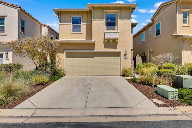 1132 Cherry Tree Ln, Vista, CA 92084 - view of front facade featuring driveway, a garage, stucco siding, and board and batten siding