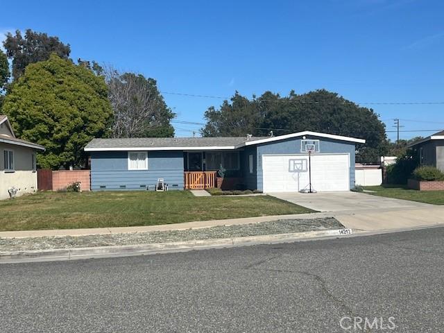 ranch-style home with driveway, fence, a front lawn, and an attached garage
