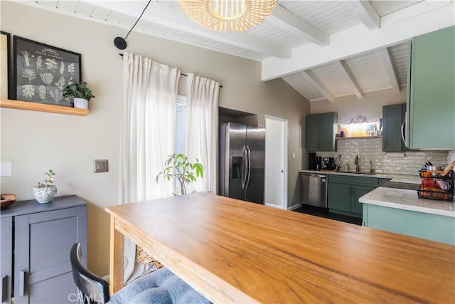 kitchen featuring green cabinetry, open shelves, a sink, appliances with stainless steel finishes, and backsplash