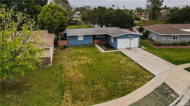 ranch-style home featuring concrete driveway and a front lawn