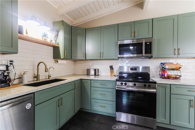 kitchen featuring appliances with stainless steel finishes, green cabinetry, open shelves, and a sink
