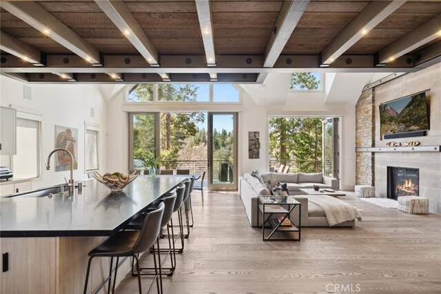 496 N State Highway 173, Lake Arrowhead, CA 92352 - living room featuring a wood ceiling with exposed beams, healthy amount of natural light, light wood-style flooring, and a fireplace
