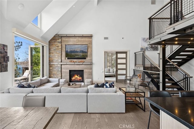 496 N State Highway 173, Lake Arrowhead, CA 92352 - living room with high vaulted ceiling, wood finished floors, a tile fireplace, and stairway