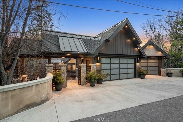 496 N State Highway 173, Lake Arrowhead, CA 92352 - view of front of house with concrete driveway, an attached garage, roof with shingles, and stone siding